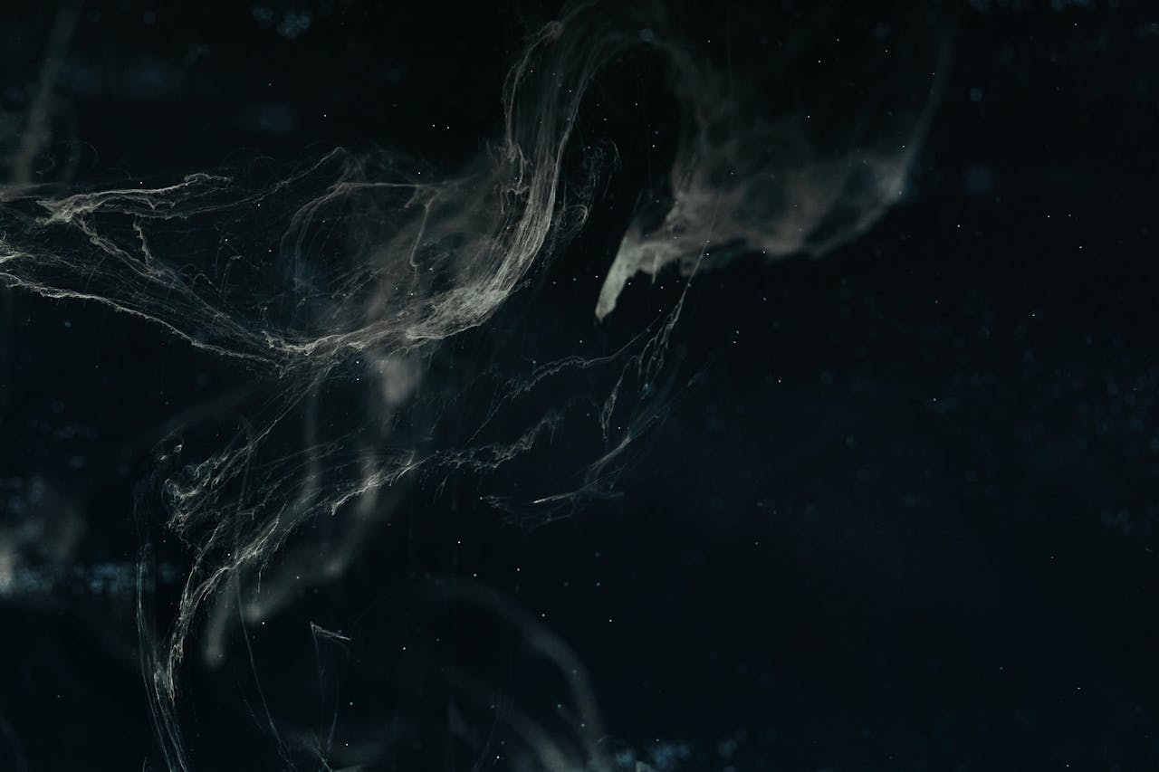 Abstract dark nebula image with swirling patterns and ethereal textures creating a cosmic feel.